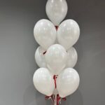 Zestaw białych balonów z czerwonymi kokardkami